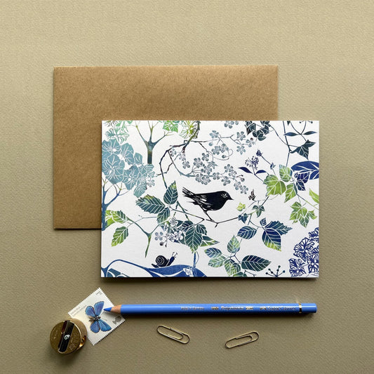 Lino print greetings card and note card of a blackbird and hydrangea and leaves in blues and greens by Laura Sowerby