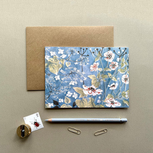 Lino print design card featuring Japanese and enemies and white climbing hydrangea on a blue background